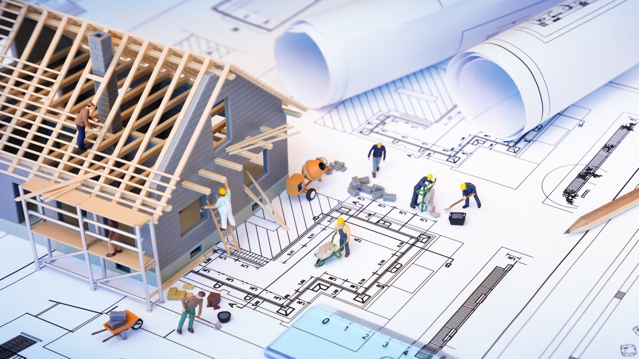 house under construction on blueprints – building project